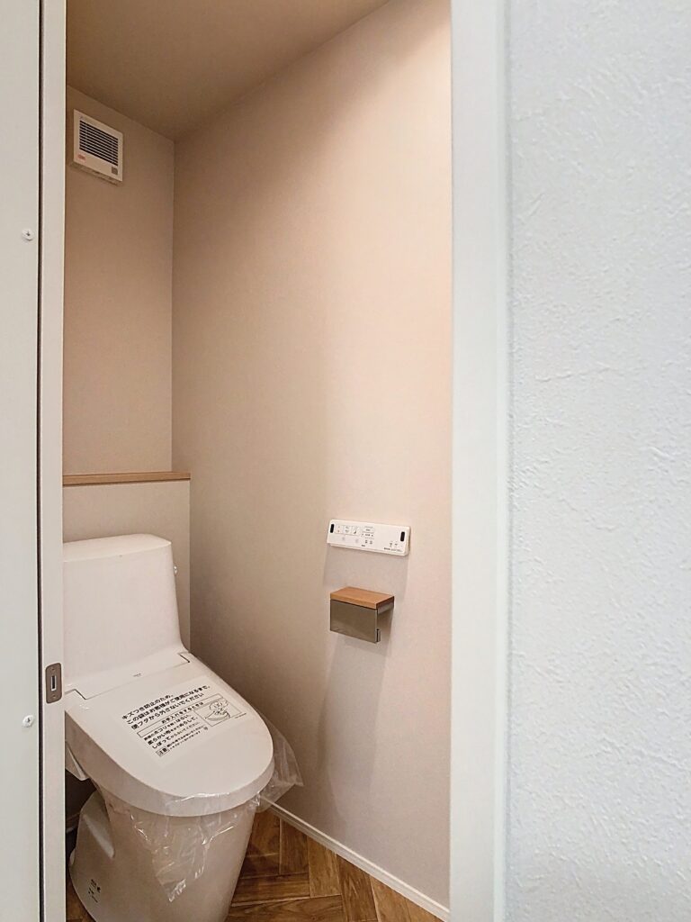 やわらかな壁色でまとめたシンプルなトイレ